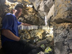 Trident plumber repairs a water leak under the foundation